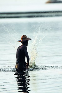 Sustainable or not? A fisherman beats the water to chase fish into nets at the Palatupana lagoon