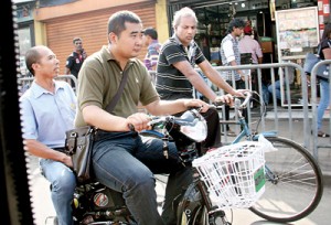 Made in China: Two Chinese take a  ride on a  Chinese-built electric motorcycle around the city.  Pic by Indika Handuwala