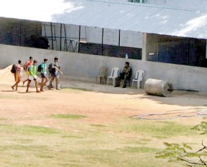 A policeman sits by the heavy roller involved in the death of a student