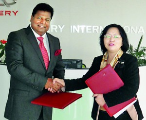 Picture shows Mr, Nalin Welgama exchanging documents with a Chery official.