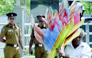 Displaying cutouts after nominations closed is prohibited by law. Here UPFA supporters in Colombo carry a cutout of no lesser person than the president himself