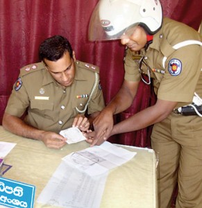 Police officers  studying the forged items. Pix by Suranga Rajanayaka