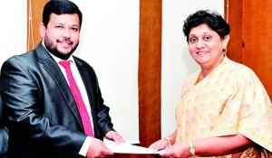 Picture shows the Minister handing over the appointment letter to Mrs. Suganthie Kadirgamar.