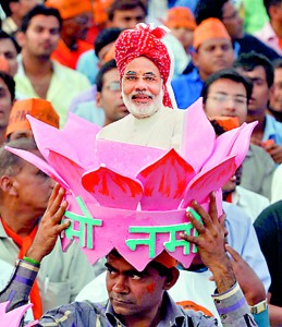 A Modi supporter wears a lotus-flower headgear with a portrait of Modi during a rally in the western Indian city of Ahmedabad. Reuters