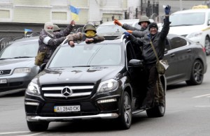 Anti-government protesters gesture as they stand on a car in the center of Kiev on February 22. The regime of Ukraine's president appeared close to collapse on February 22 as the emboldened opposition took control of central Kiev and key government and parliament positions and voted to immediately free its jailed leader Yulia Tymoshenko (AFP)