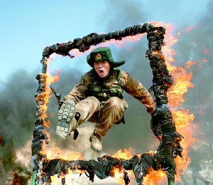 This picture taken on March 5, 2014 shows a soldier jumping over a ring of fire during a tactical training mission in Heihe, northeast China's Heilongjiang province. The latest double-digit increase to China's defence budget serves world peace and is no threat to anyone, state media argued (AFP)