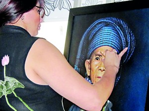 The artist gives expression to the portrait of a Burmese Kayan woman