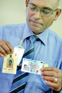 Mr. Kumara holds up an old NIC and one with computerised features which he says is the steppingstone to the eNIC. Pix by Athula Devapriya