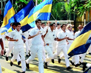 Fun on the streets: Young Royalists in a rush, flags aloft in the pre-Big Match parade while the blue and black Thomian flags fly high on the first day of the match. Pix by Athula Devapriya  and Amila Gamage