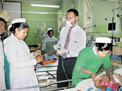 Consultant Virologist Dr. JudeJayamaha collects samples at the Nuwara Eliya Hospital in 2014. Inset left: The Respiratory Syncytial Virus highlighted in green