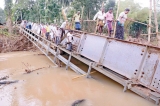 Flood victims risk lives on overturned bridge