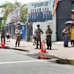 Police and army personnel stand watch