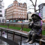 Leicester Square in London: Paddington perched eating a sandwich on a bench