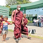 New show at the zoo? Monks walk past as two legged species take centre stage instead of the usual four legged ones.  Pic by Indika Handuwala
