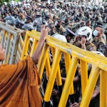 Borella: Outnumbered: A buddhist monk stands on one side of a Police barricade 					    	         Pix by M A Pushpa Kumara