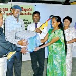 Milton Amarasinghe handing over the required musical instruments for the Western band to H.M.M. P Herath and music teacher R.M.B. Gayashani.