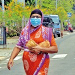 Vauxhall Street: Priced posssesion: A woman holds close two coconuts, essential in Lankan cooking