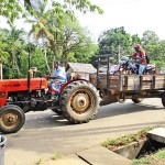 Karuwalagasvewa-Hitching a ride: A tractor carts a bike rider Pic by Jayarathna Wickramaarachchi