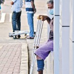 Kollupitiya-Limited options: A man with crutches waits in anticipation Pix by Eshan Fernando