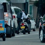 Rajagiriya Fast lane: A man pushes his scooter to overtake vehicles in traffic Pix by Eshan Fernando