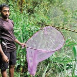 Arumugam's brother  holds up his  brother's fishing net