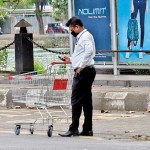 Nawam Mawatha Grocery shopping: A man stands with an empty super market shopping cart at a bus stop. Pic by Akila Jayawardena