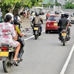 Kotte Risky travel: A bike passenger sans helmet braves the ride among bigger vehicles. Pix by Eshan Fernando