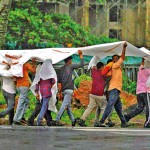 Slave Island: Together we stand: Workers share shelter in the rain. Pix by Eshan Fernando