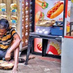 Panchikawatte- Wayside meal: A worker eats his meal by the side of the road.  Pix by Eshan Fernando