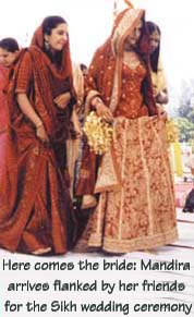 Here comes the bride: Mandira arrives flanked by her friends for the Sikh wedding ceremony