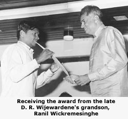 Receiving the award from the late D. R. Wijewardene's grandson