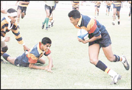 OFF I go - one of the Trinity players with ball in hand is looking for a breakthrough to go for a try as a Royal  player makes to foil him in an incident at  the Bradby Shield first leg match at the Sugathadasa Stadium yesterday.