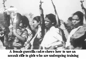 A female guerrilla cadre shows how to use assault rifle to girls who are undergoing training