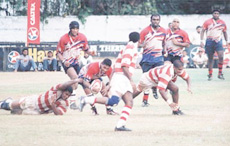 Nalaka Weerakkody, who showd a touch of class for Kandy, is tackled by a CH player with Kandy and CH players moving in support. Kandy beat CH 46-8 to win the Caltex League title. Pictures by M.A. Pushpakumara.