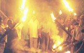 With election campaigns starting amidst power cuts, party supporters, bearing traditional torches, escort their candidates along unlit streets during the house-to-house campaign. Here UNP's Kaduwela organiser Karunasena Kodituwakku is seen with his supporters. Pic by Gemunu Wellage