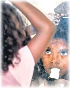 A Sri Lankan refugee child Anoja combs her hair