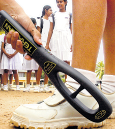 A girl's shoe is being subjected to a metal detector test.