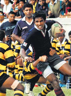 A Kingswood player with the ball looks for a break, but is held back by the Royal defence. 