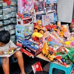 Pettah Toys for others: Two children pass their time at a toy stall. Pix  by Eshan Fernando