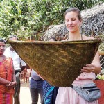 A tourist using a winnow to sift the chaff from the rice