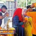 STAJ-08---Pedestrians-drink-king-coconuts-at-the-Fort-Stataiton