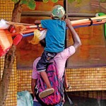 Pamankada: Broom, broom: A child hitches a ride on a broom vendor Pic by Akila Jayawardena