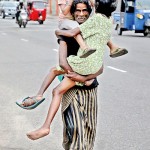 Colombo 3 - Heavy load: A man carries a child and an injured person