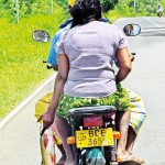 Udawalawe Day's catch: A pillion rider  holds onto a fish Pic by Nilan Maligaspe