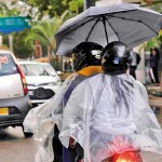 Gangaaramaya: Make-do: People on a bike brave the weather