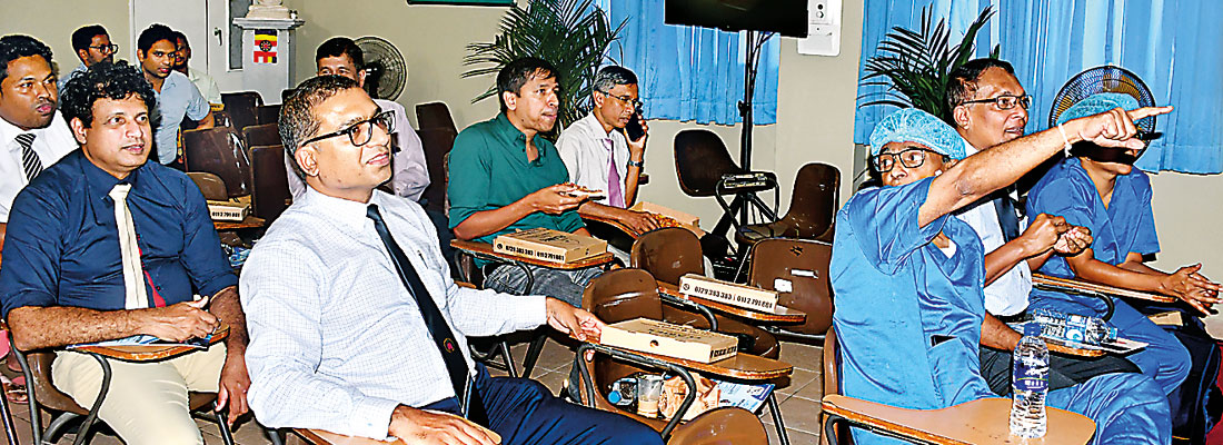 Doctors and close relatives of patient watch mitral valve repair on a screen