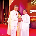 Diyawadana Nilame Pradeep Nilanga Dela presenting the token of appreciation to Professor Ashoka Dangolla