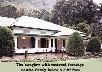 The bungalow with restored frontage nestles firmly below a cliff face.