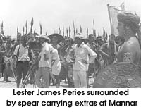 Lester James Peries surrounded by spear carrying extras at Mannar