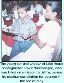 The young son and widow of Lake House photographer Edwin Weerasinghe, who was killed on a mission to Jaffna, peruse his posthumous citation for courage in the line of duty